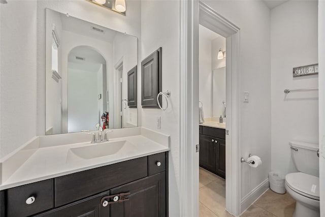 bathroom with toilet, tile patterned flooring, visible vents, and vanity