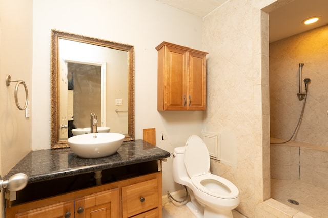 bathroom featuring vanity, toilet, and tiled shower