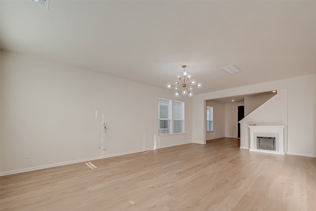 unfurnished living room featuring light hardwood / wood-style floors and a chandelier