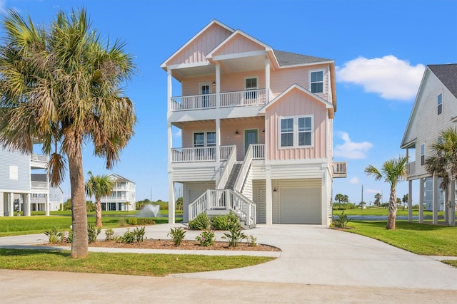 26831 Bay Water Dr, Galveston, TX 77554 - coastal home with board and batten siding, a porch, driveway, a balcony, and stairs