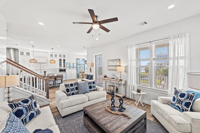 26831 Bay Water Dr, Galveston, TX 77554 - living room featuring recessed lighting, a ceiling fan, wood finished floors, visible vents, and stairway