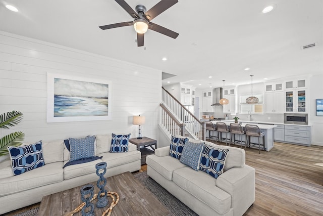 26831 Bay Water Dr, Galveston, TX 77554 - living area featuring a ceiling fan, visible vents, wood walls, light wood-style floors, and recessed lighting