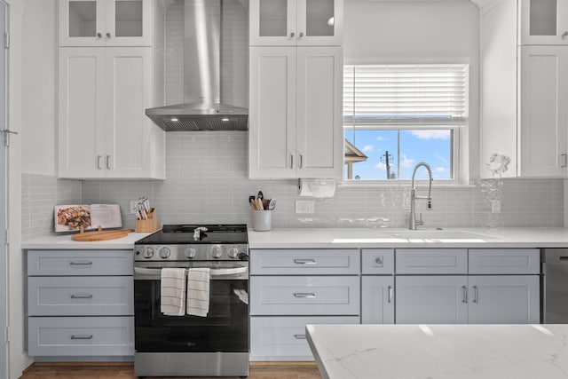 26831 Bay Water Dr, Galveston, TX 77554 - kitchen featuring backsplash, appliances with stainless steel finishes, a sink, white cabinets, and wall chimney exhaust hood