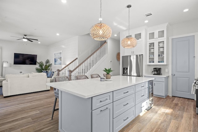 26831 Bay Water Dr, Galveston, TX 77554 - kitchen featuring light wood-style floors, stainless steel fridge with ice dispenser, a kitchen bar, and visible vents