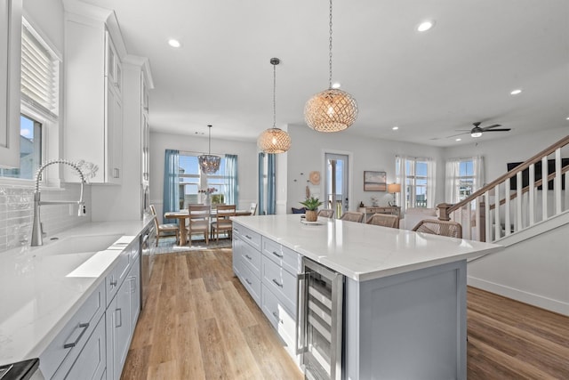 26831 Bay Water Dr, Galveston, TX 77554 - kitchen featuring wine cooler, recessed lighting, a center island, a sink, and light wood finished floors