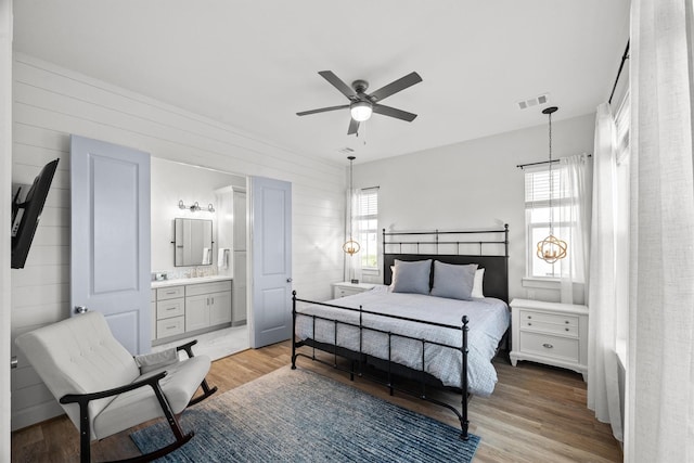 26831 Bay Water Dr, Galveston, TX 77554 - bedroom with ensuite bath, ceiling fan, visible vents, and light wood-style floors