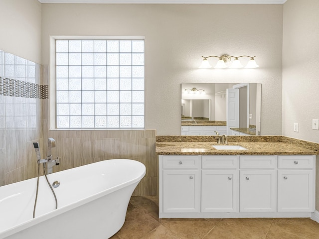 bathroom featuring vanity, tile patterned flooring, and a bathtub