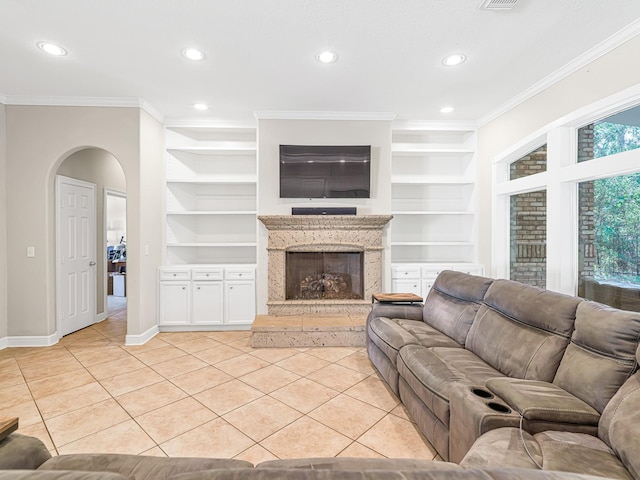 living room with light tile patterned floors, crown molding, arched walkways, and built in features