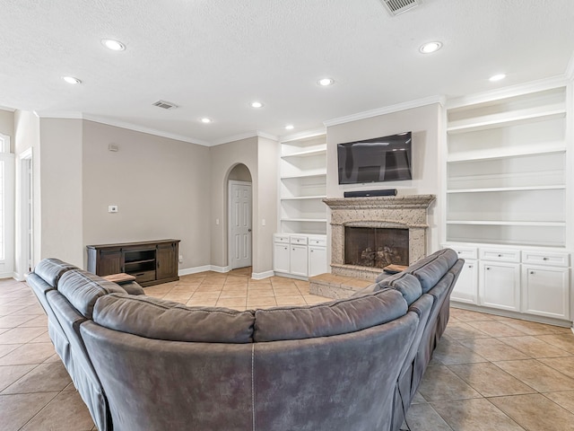 living area with built in shelves, arched walkways, a high end fireplace, light tile patterned flooring, and a textured ceiling