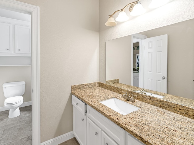 bathroom featuring toilet, tile patterned flooring, baseboards, and vanity