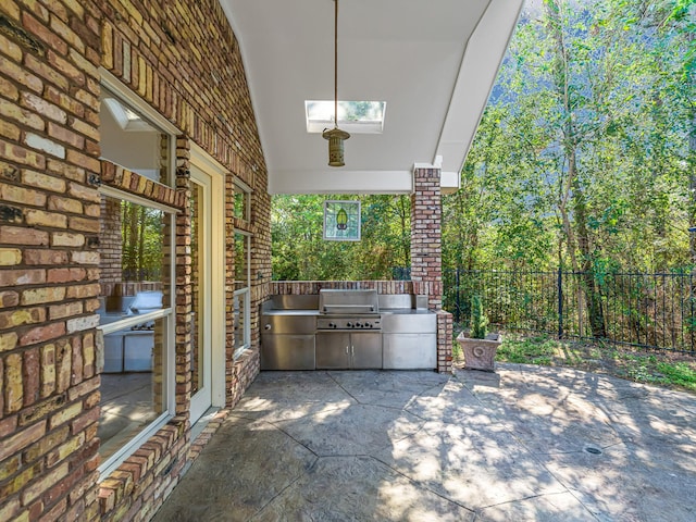 view of patio with a grill, fence, and area for grilling