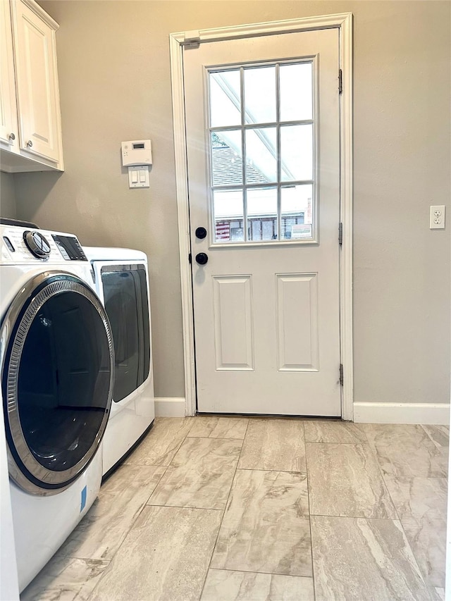 laundry room with separate washer and dryer and cabinets