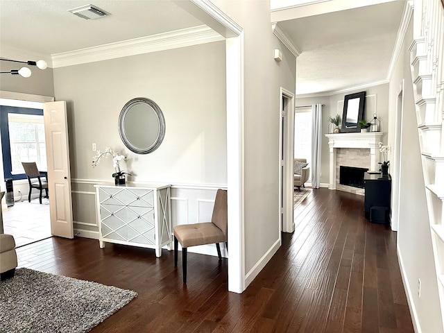 hall with dark wood-type flooring and ornamental molding