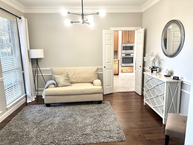 living area featuring dark hardwood / wood-style flooring, crown molding, and a chandelier