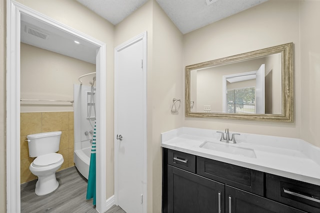 full bathroom featuring wood-type flooring, tile walls, toilet, vanity, and bathing tub / shower combination