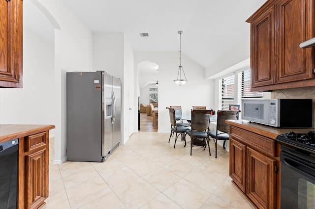 kitchen with backsplash, black appliances, decorative light fixtures, light tile patterned floors, and high vaulted ceiling