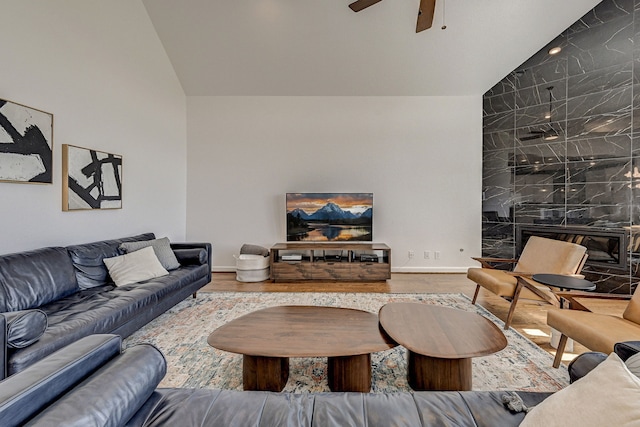 living room with lofted ceiling, a fireplace, hardwood / wood-style flooring, and ceiling fan