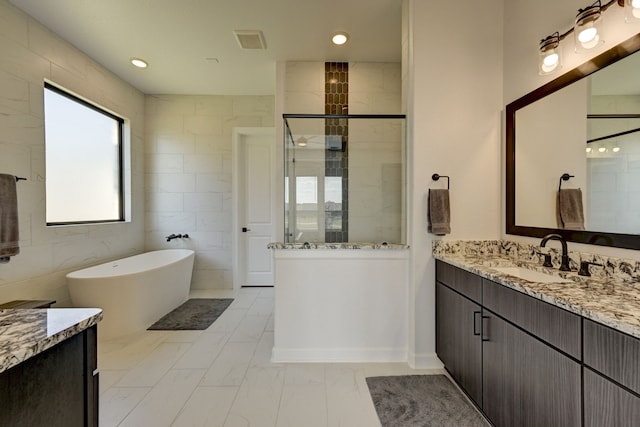 bathroom featuring vanity, tile walls, and shower with separate bathtub