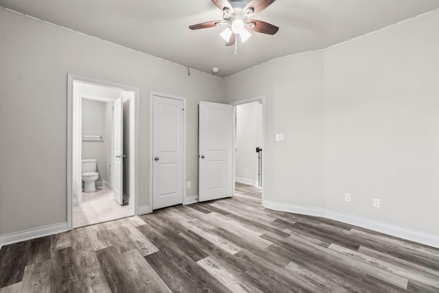 unfurnished bedroom with connected bathroom, ceiling fan, and hardwood / wood-style flooring