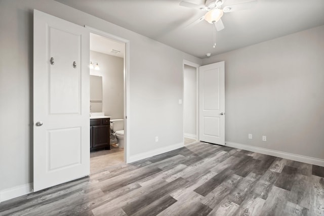 unfurnished bedroom featuring hardwood / wood-style floors, ceiling fan, and ensuite bath