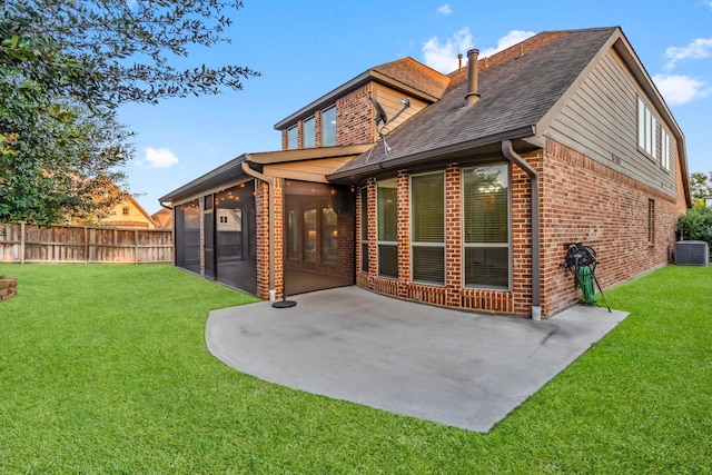 back of house featuring a sunroom, central AC unit, a patio area, and a lawn