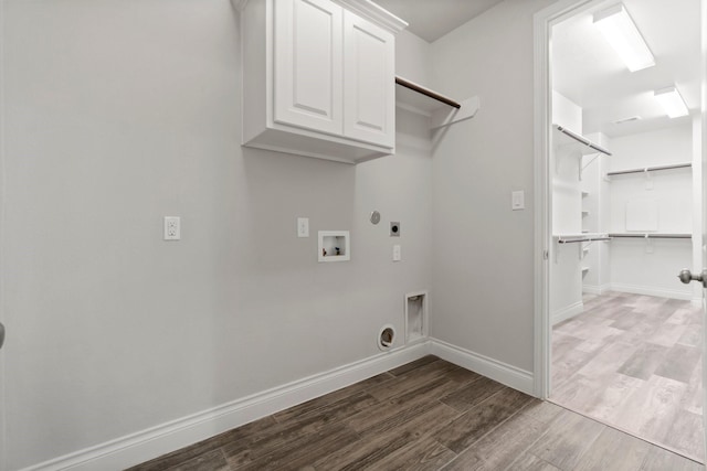 laundry room with electric dryer hookup, hookup for a washing machine, and cabinets