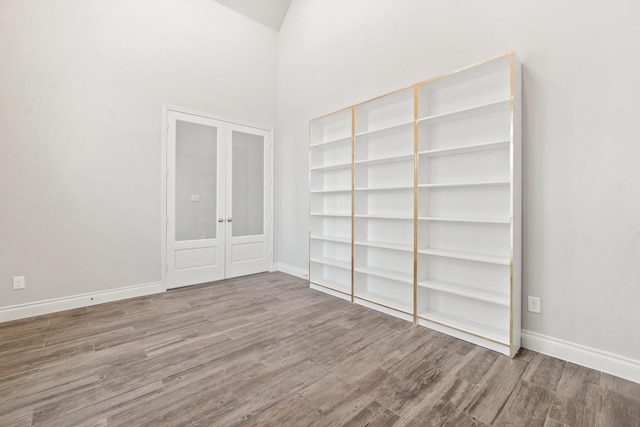 spare room featuring a high ceiling and hardwood / wood-style flooring