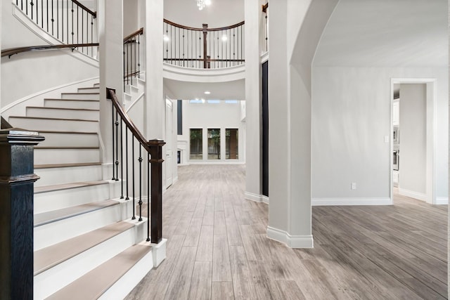 foyer with a towering ceiling and light wood-type flooring