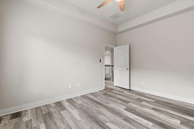 empty room with ceiling fan and light hardwood / wood-style floors