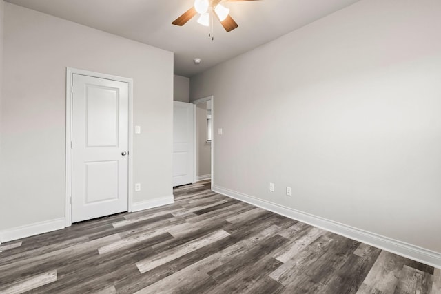 unfurnished bedroom featuring ceiling fan and dark hardwood / wood-style floors