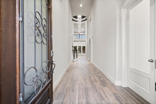 corridor featuring a high ceiling and hardwood / wood-style flooring