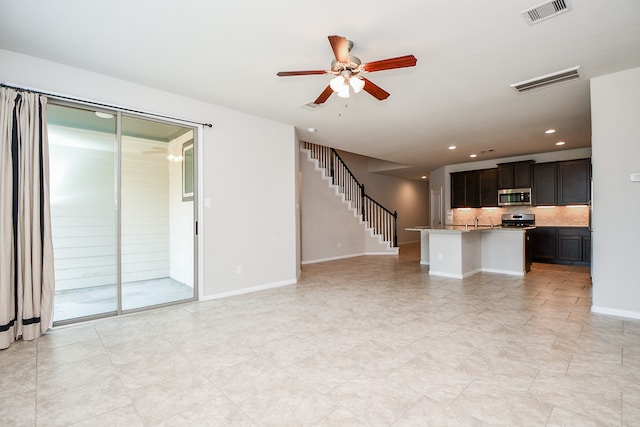 unfurnished living room with ceiling fan and sink