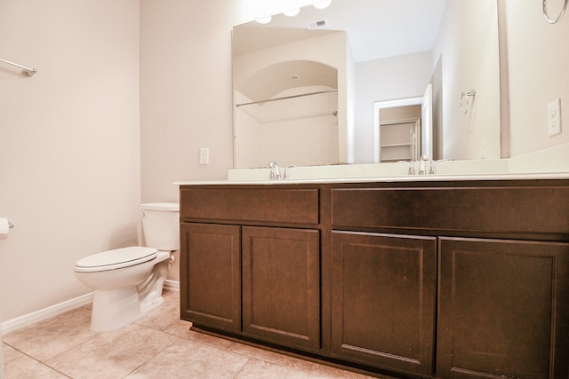 bathroom with vanity, a shower, toilet, and tile patterned floors