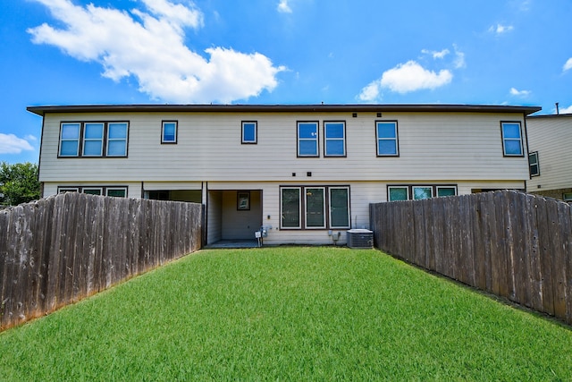 back of property with a yard and central air condition unit