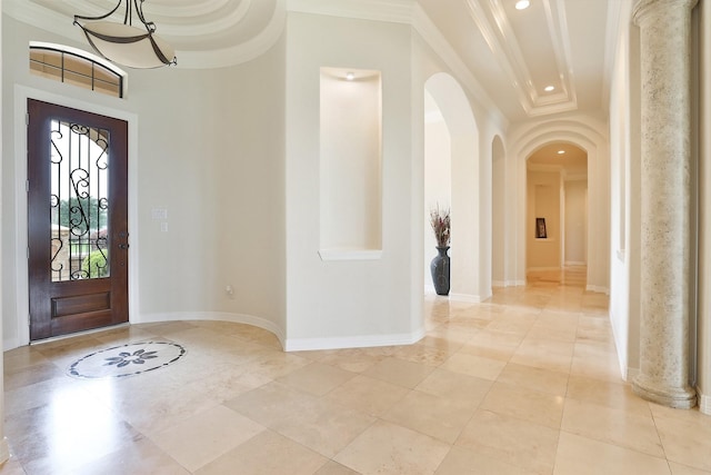 entryway featuring a raised ceiling and crown molding