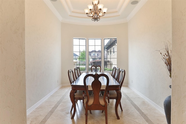 dining room with a chandelier, a raised ceiling, and crown molding