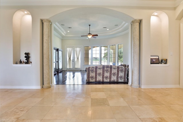 unfurnished living room with french doors, decorative columns, a raised ceiling, ceiling fan, and crown molding