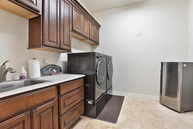 washroom featuring washer and clothes dryer, cabinets, and sink