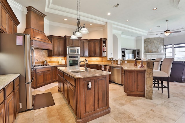 kitchen with pendant lighting, a center island with sink, sink, a kitchen bar, and stainless steel appliances