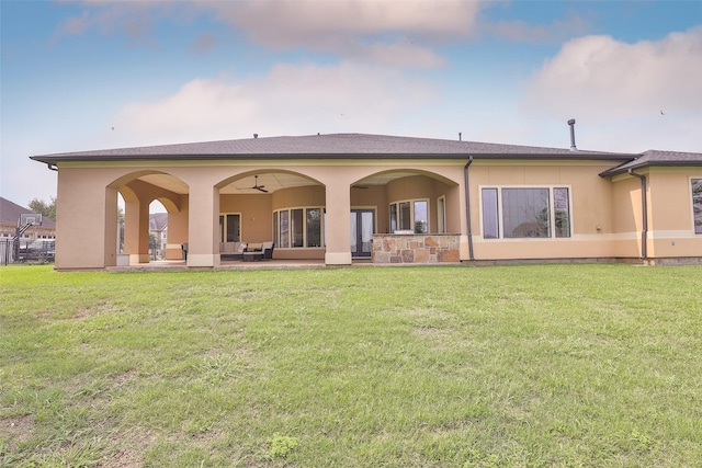 rear view of property featuring outdoor lounge area, ceiling fan, a patio area, and a lawn