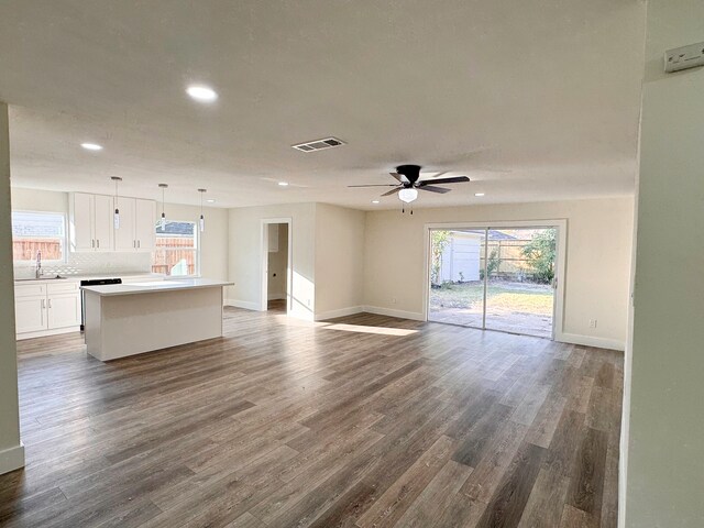 unfurnished living room featuring sink, ceiling fan, and dark hardwood / wood-style flooring