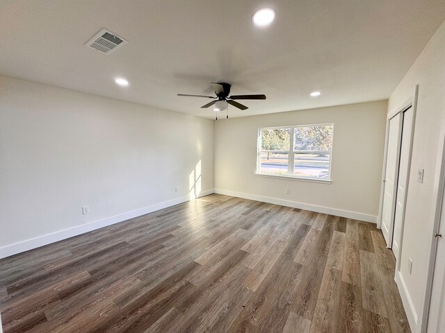 empty room with dark hardwood / wood-style floors and ceiling fan