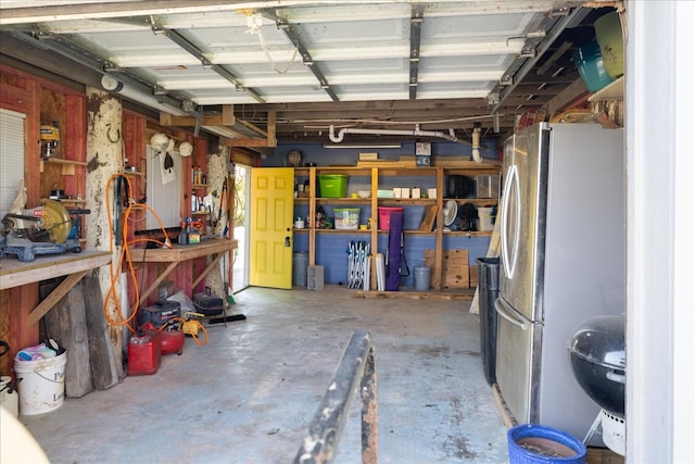 garage with stainless steel fridge and a workshop area