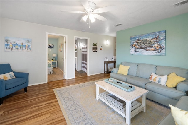 living room featuring wood-type flooring and ceiling fan