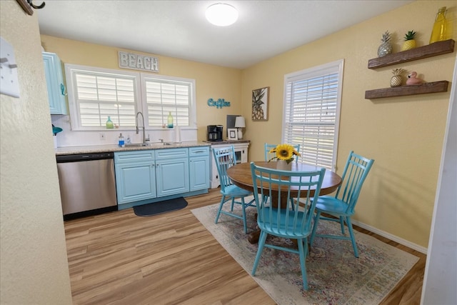 kitchen with blue cabinets, dishwasher, light wood-type flooring, and sink