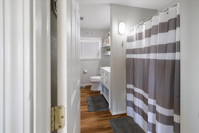 bathroom with toilet, hardwood / wood-style floors, and vanity