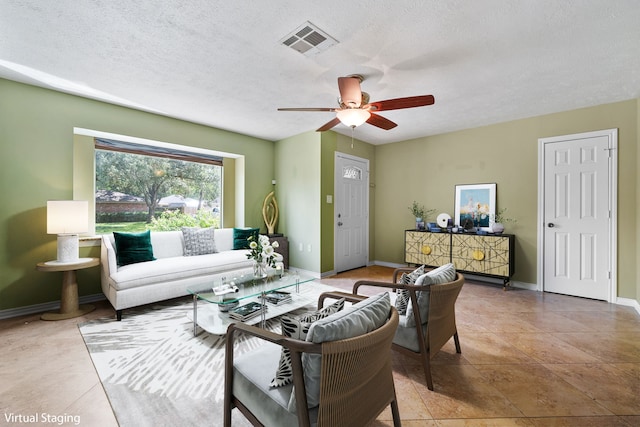 tiled living room with ceiling fan and a textured ceiling