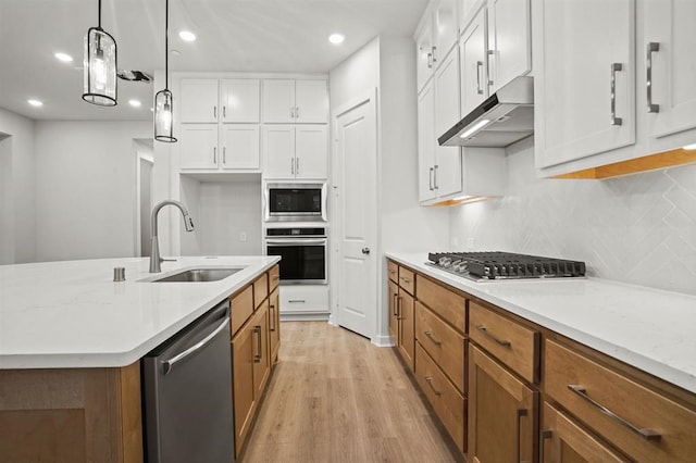 kitchen featuring white cabinetry, sink, pendant lighting, and appliances with stainless steel finishes