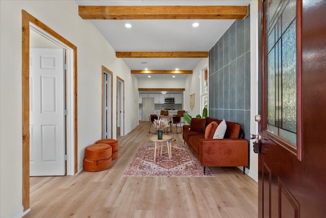 interior space featuring beam ceiling, tile walls, and light hardwood / wood-style floors