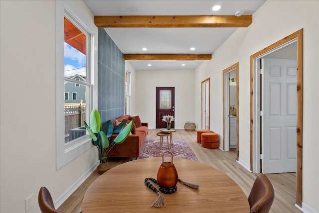 dining area featuring light hardwood / wood-style flooring, beam ceiling, and plenty of natural light